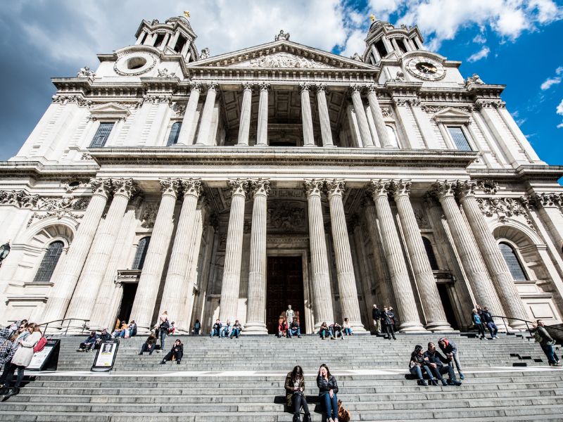 Menschen sitzen auf den Treppen vor dem Eingang zur Kirche St Paul's in London