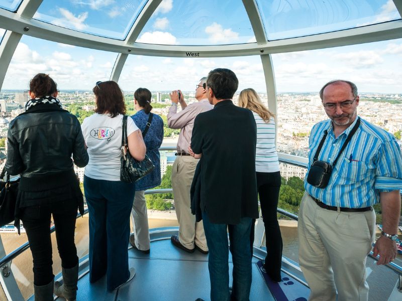 Touristen machen Fotos während Fahrt mit Riesenrad London Eye
