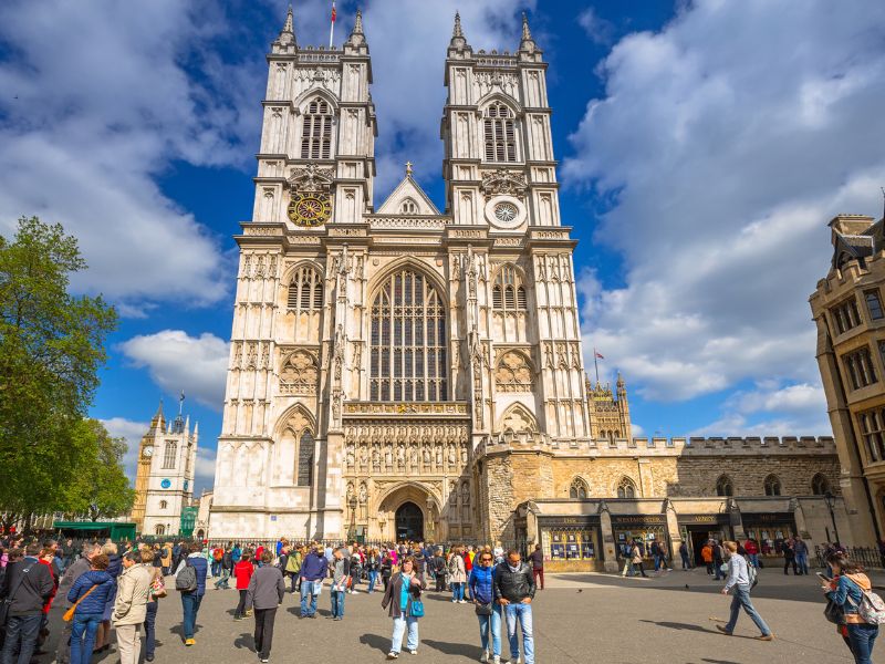Touristen vor den zwei Türmen des Gotteshauses Westminster Abbey in London