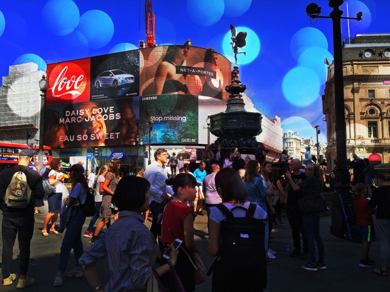 Touristen und Einheimische vor dem Brunnen und Reklametafeln am Piccadilly Circus