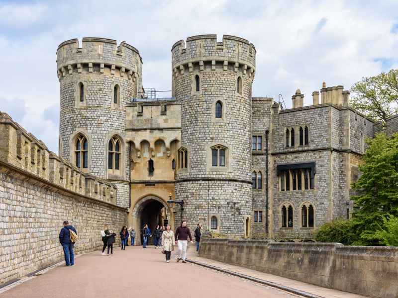 Touristen vor Schloss Windsor mit Türmen und Mauer