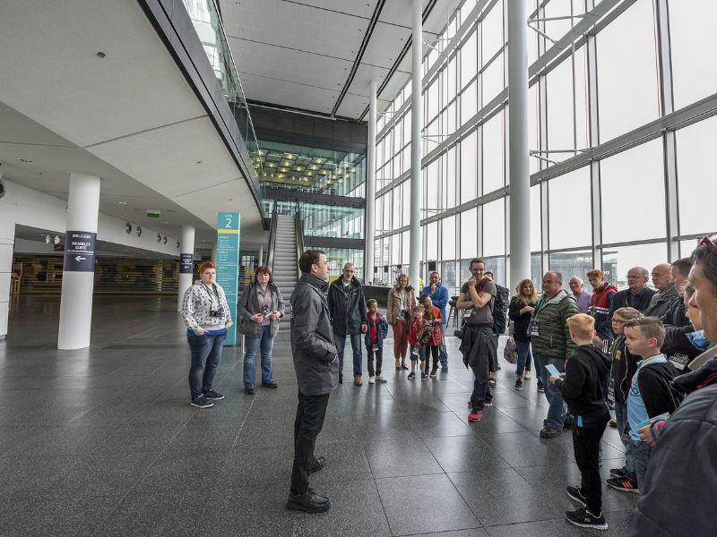 Guide mit Besuchergruppe bei Stadiontour durch das Wembley