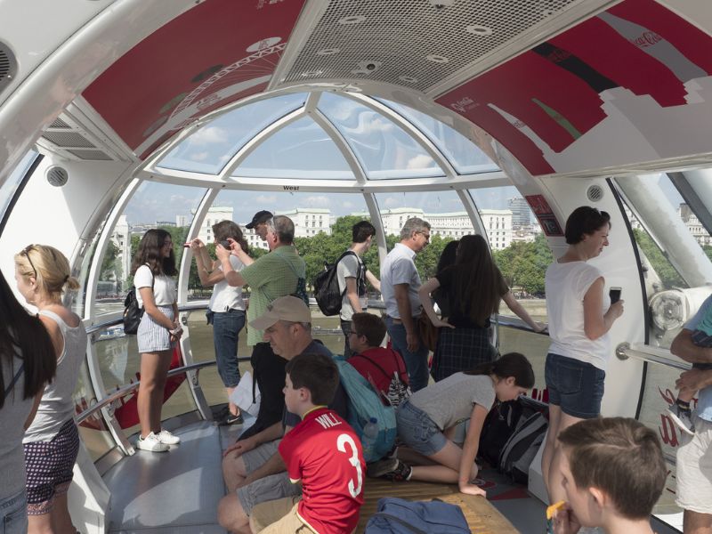 Man teilt die Gondel vom Riesenrad in London mit anderen Touristen