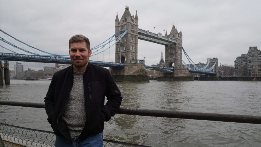 Autor Christoph an der Themse in London mit Tower Bridge dahinter